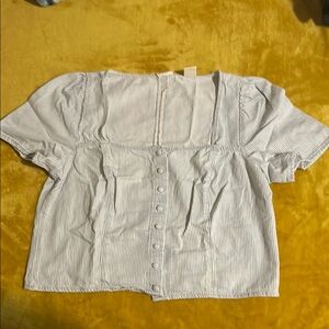 White short-sleeved blouse with square neckline and vertical pleats